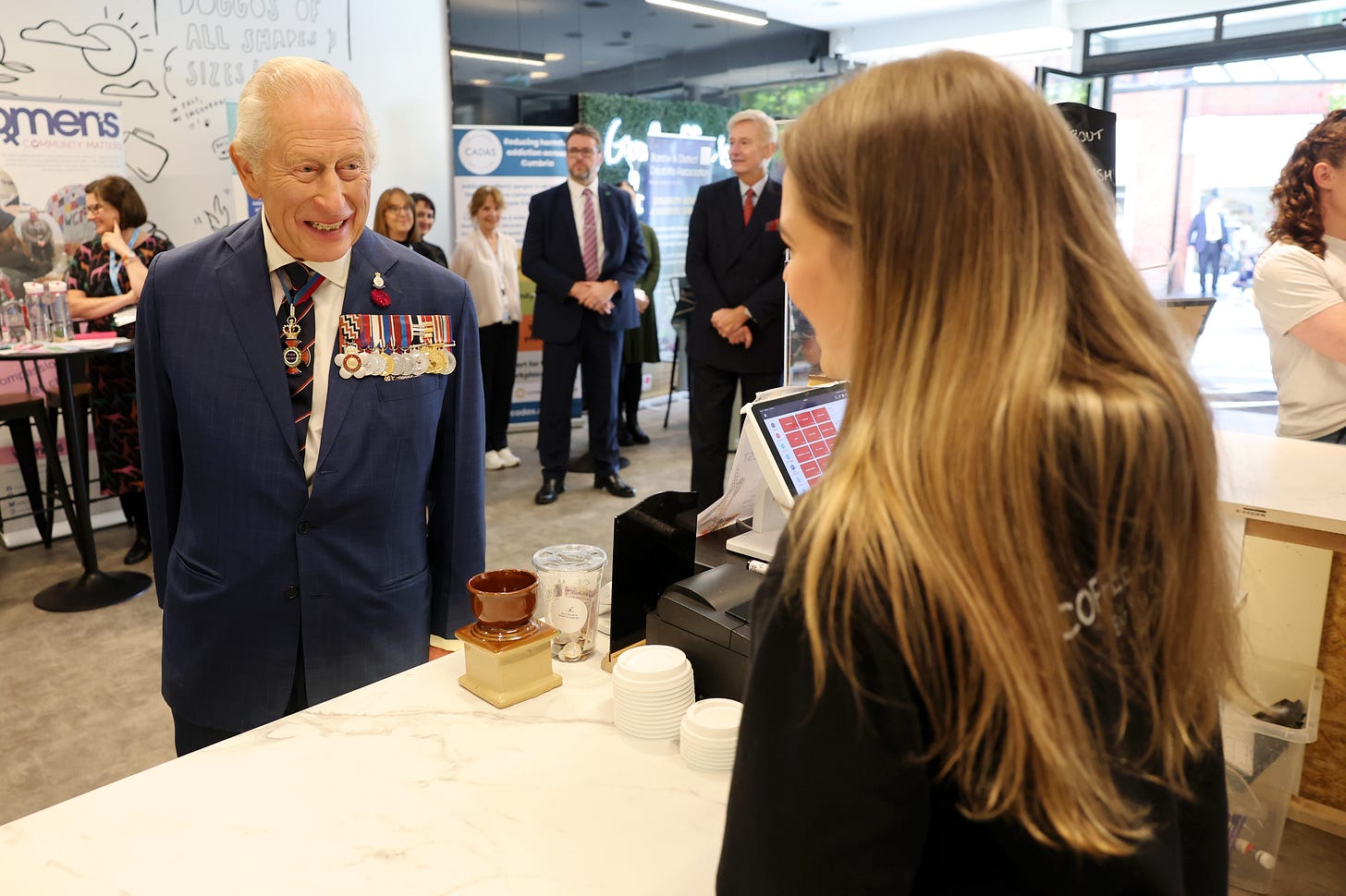 King Charles laughing at something amusing at a coffee shop in Barrow King Charles laughing at something amusing at a coffee shop in Barrow