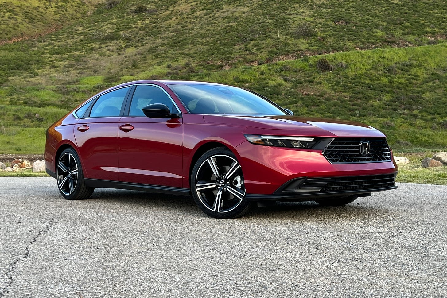 Front view of a red 2023 Honda Accord Sport parked in a lot near mountains.