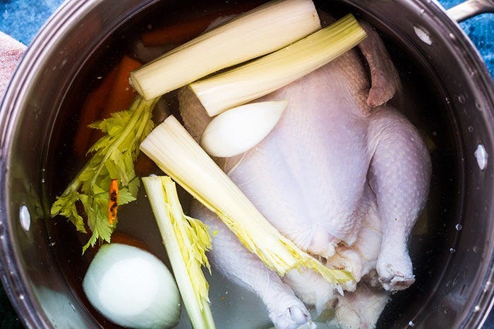 chicken and aromatics simmering for ginger turmeric chicken soup chicken and aromatics simmering for ginger turmeric chicken soup