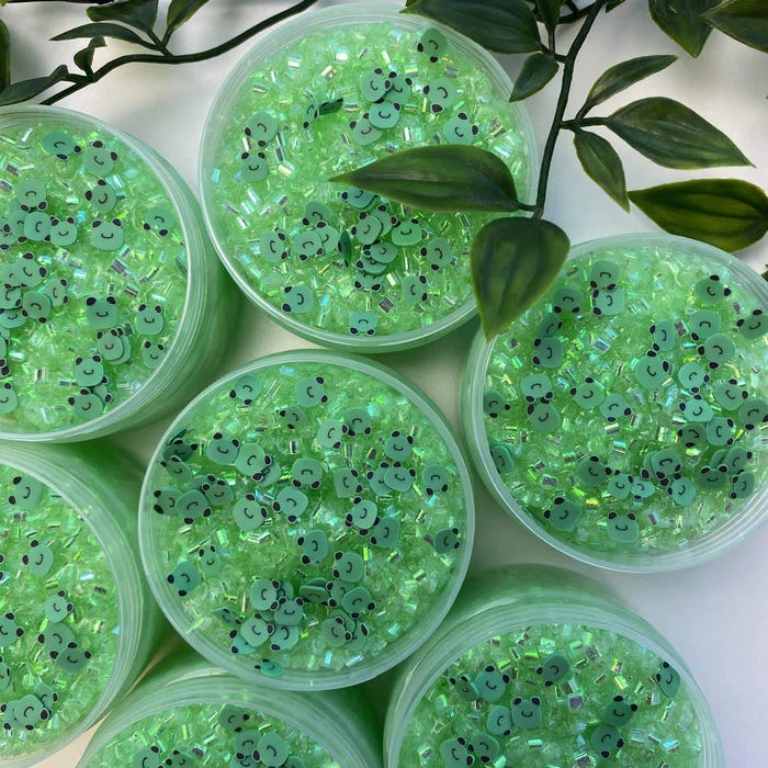 Containers of green frog-themed Bingsu slime on a table