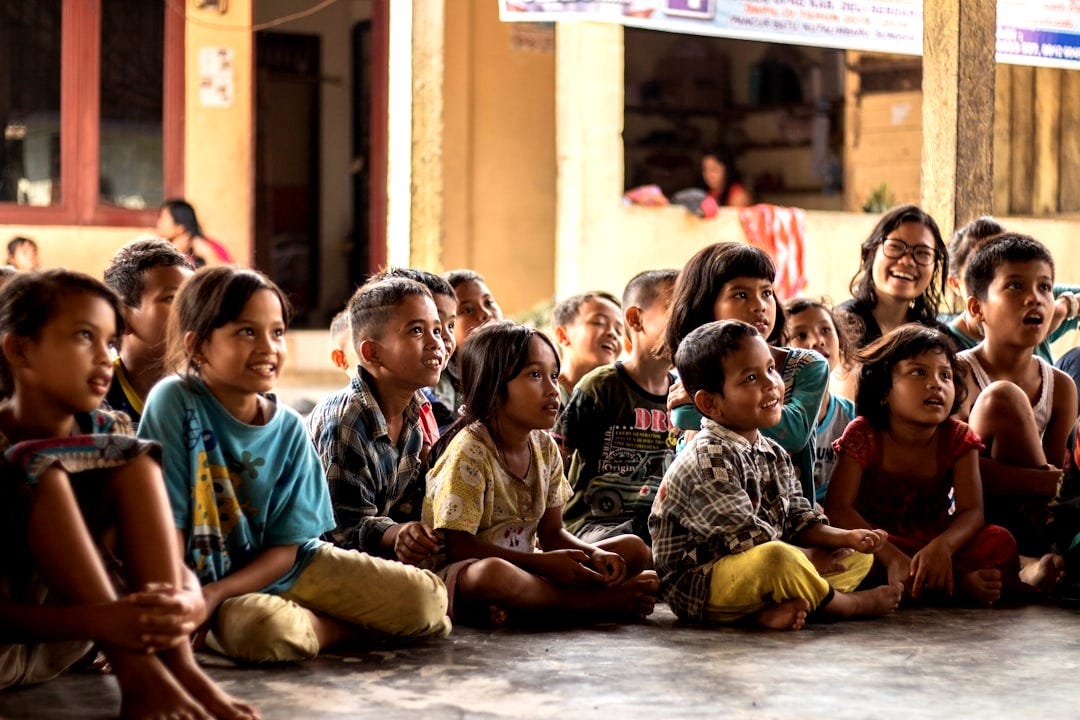 group of childrens sitting on ground