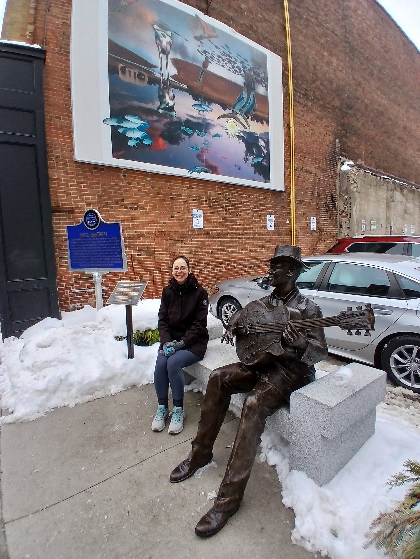 Me, sitting near the marker and plaque, trying not to look cold.
