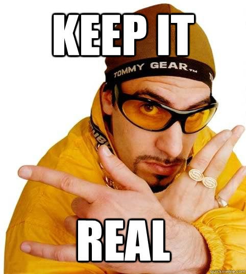 Man in yellow jacket and glasses, striking a pose with a serious expression. Text reads "KEEP IT REAL" in bold letters.