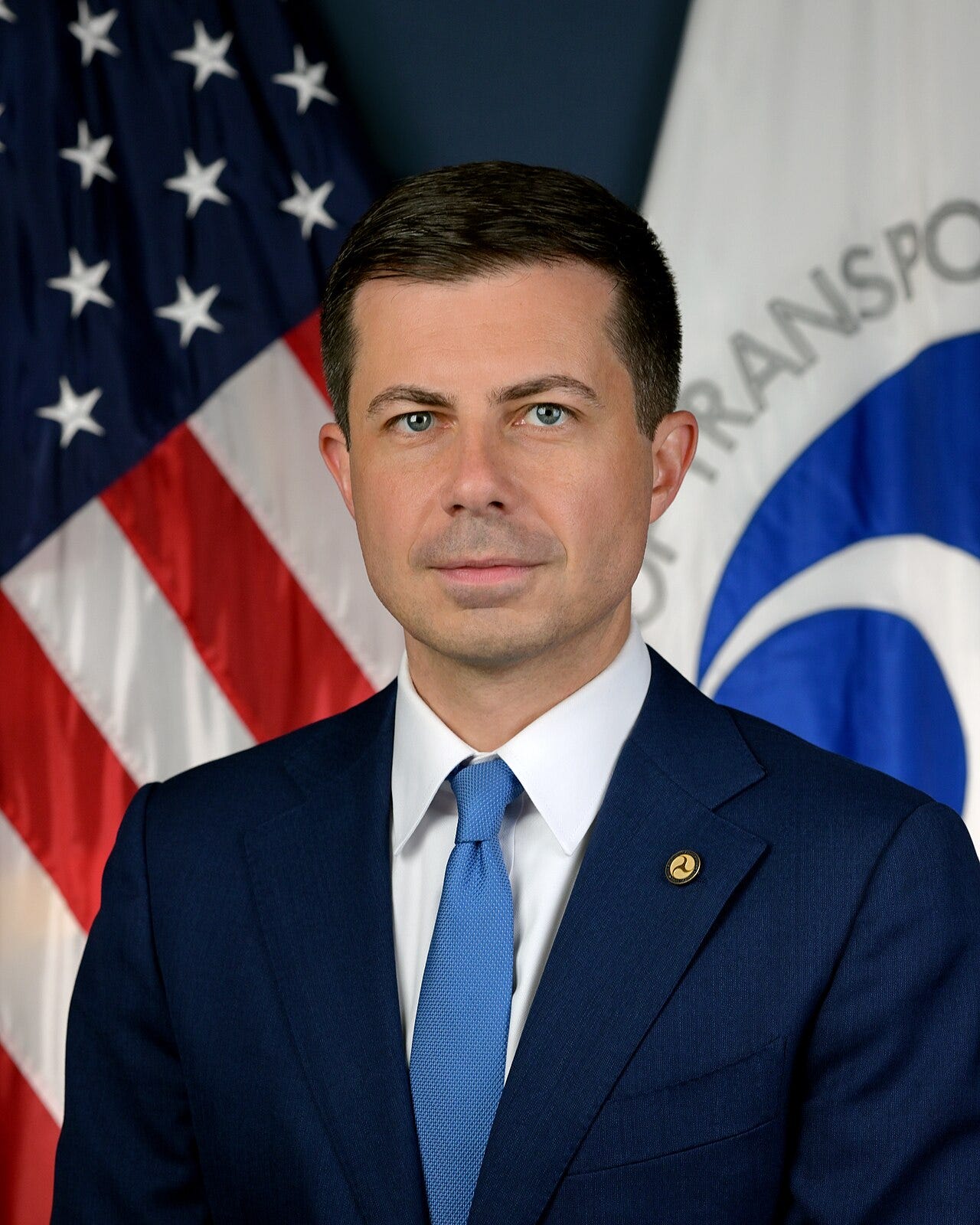 Pete Buttigieg's photo as transportation sec; dark jacket, blue tie, white youngish man with short cropped hair Pete Buttigieg's photo as transportation sec; dark jacket, blue tie, white youngish man with short cropped hair