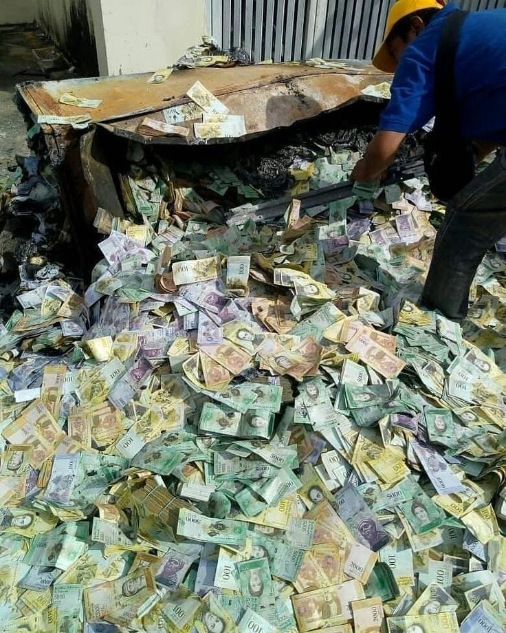 This may contain: a pile of money sitting on top of a floor next to a man wearing a hard hat