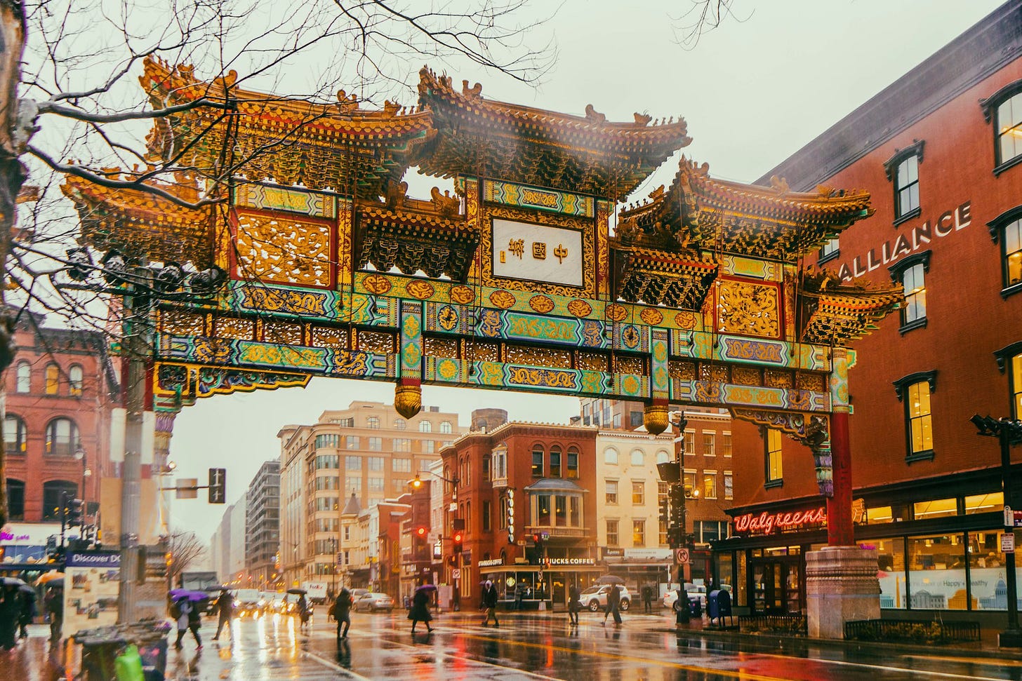 Fotografia em cores da entrada da chinatown de Washington. É possível ber um portão tipicamente chinês em um cenário tipicamente estadunidense. Fotografia em cores da entrada da chinatown de Washington. É possível ber um portão tipicamente chinês em um cenário tipicamente estadunidense.