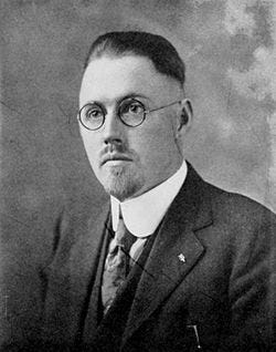 A person in a suit and glasses

AI-generated content may be incorrect.