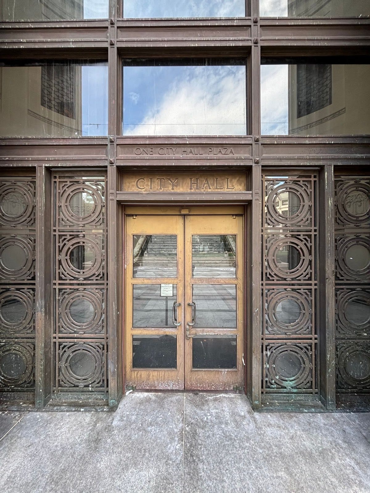 The front door to Oakland City Hall, with a closed sign indicating that this entrance is not in use and directing visitors to a side door. Oakland, California, November 6, 2025. (Image source: Oakland Report) The front door to Oakland City Hall, with a closed sign indicating that this entrance is not in use and directing visitors to a side door. Oakland, California, November 6, 2025. (Image source: Oakland Report)