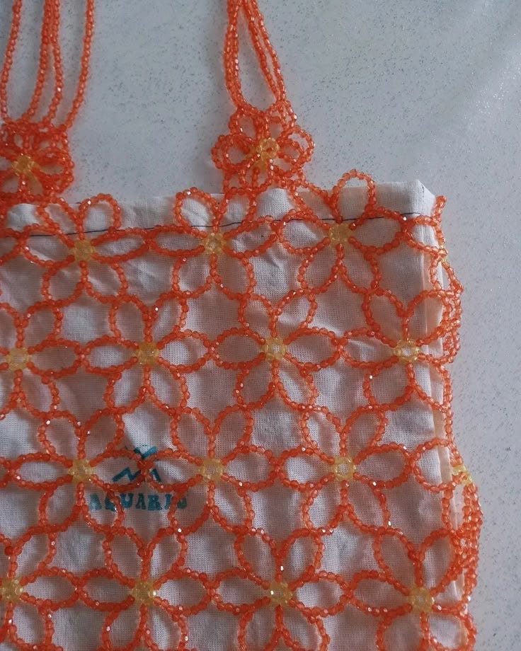 This may contain: an orange netted bag sitting on top of a table