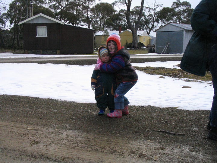 Children play and pose for photographs in snow in Tasmania
