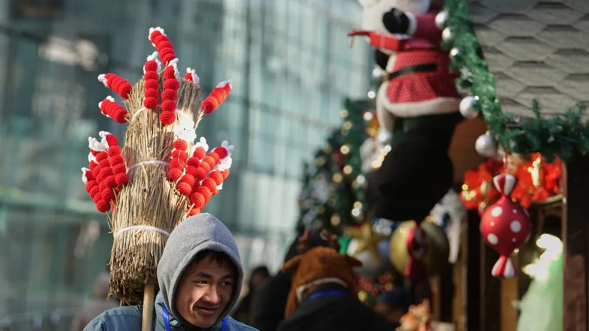 中国北京,一名工作人员手持仿制的糖果棒招揽民众,宣传购物中心外举办的冬季嘉年华活动。(美联社) 中国北京,一名工作人员手持仿制的糖果棒招揽民众,宣传购物中心外举办的冬季嘉年华活动。(美联社)