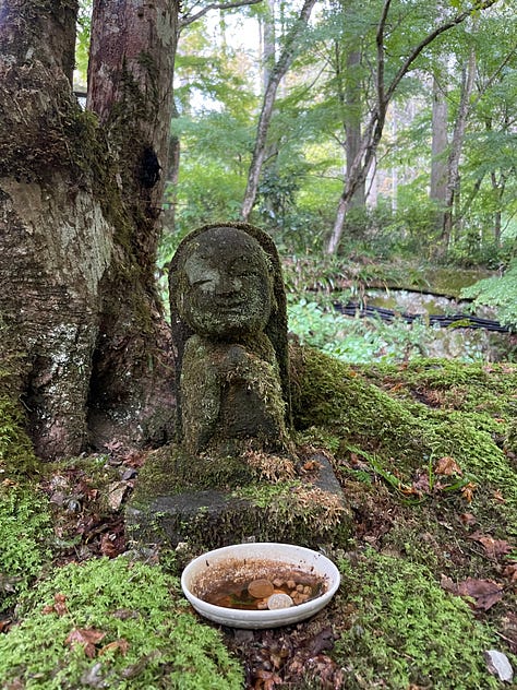 A collage of nine photos from Japan: a man in traditional kimono performing a tea ceremony; a tray of delicate kaiseki dishes with seasonal ingredients; a serene temple garden surrounded by moss and trees; a tatami room with sliding shoji doors; a mountain view with Mount Fuji in the distance; a bowl of Japanese dessert with green grapes and jelly; a Shinto wedding procession under a red umbrella; a moss-covered stone Buddha statue in a forest; and misty temple grounds framed by lush greenery.