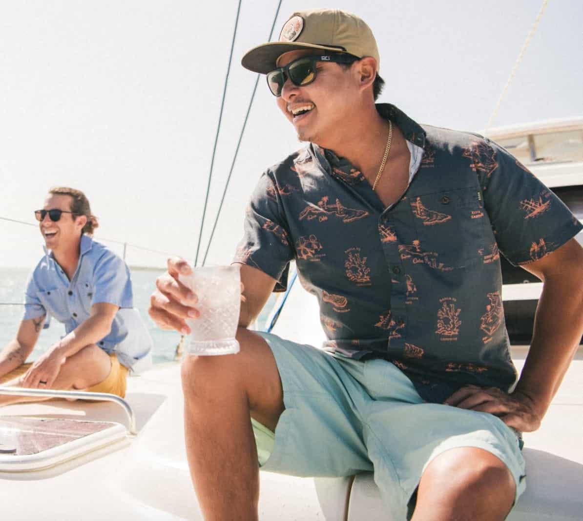 man sitting on boat wearing howler bros horizon hybrid shorts