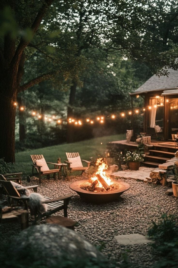 This may contain: an outdoor fire pit surrounded by chairs and lights
