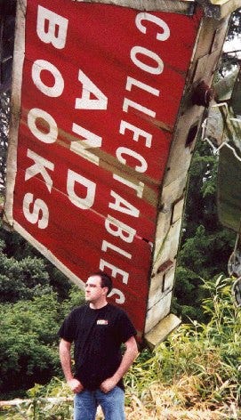 Brian in front of a ruined and collapsed bookstore.