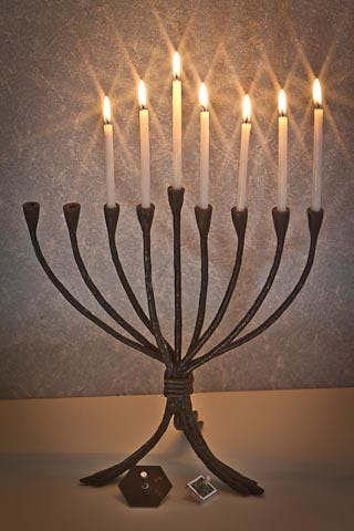 A candles on a metal candelabra

Description automatically generated
