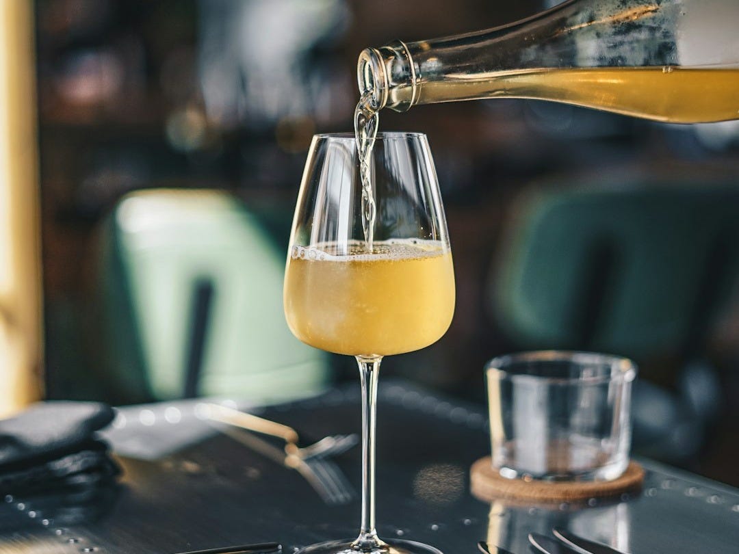 a glass of wine being poured into a wine glass a glass of wine being poured into a wine glass