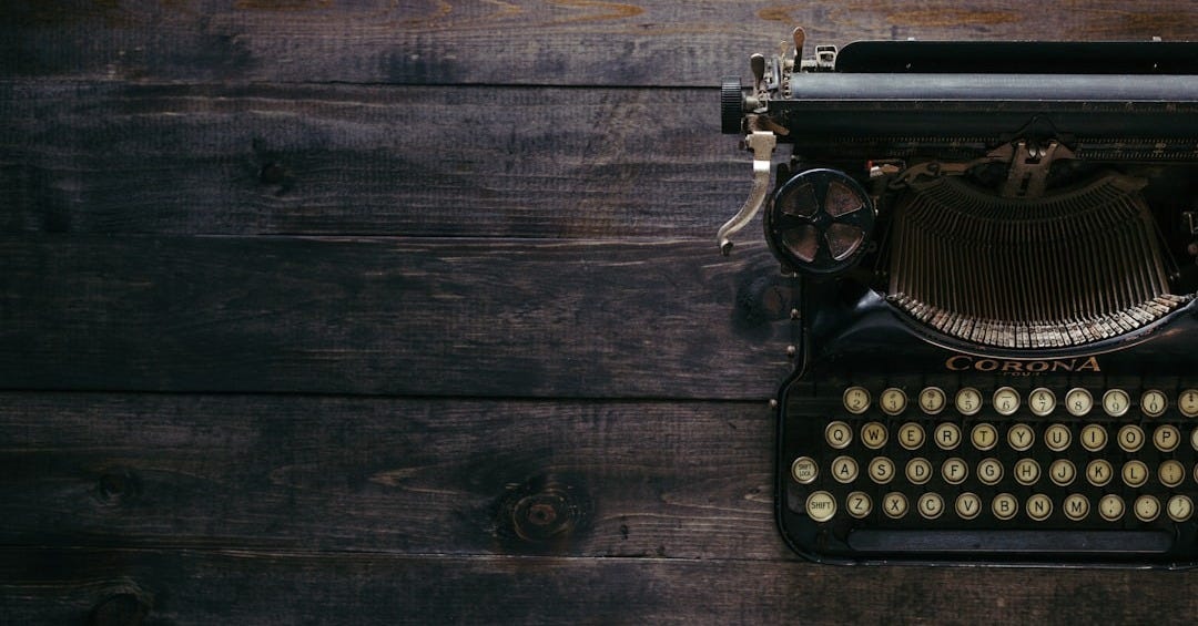 black Corona typewriter on brown wood planks