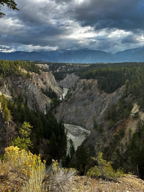 a river at the bottom of a beautiful canyon, contrasted against a cloudy sky a river at the bottom of a beautiful canyon, contrasted against a cloudy sky