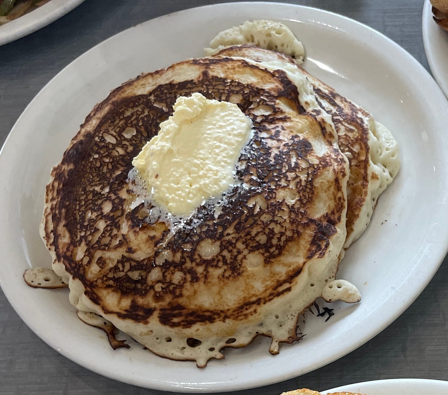 A stack of pancakes covered in butter