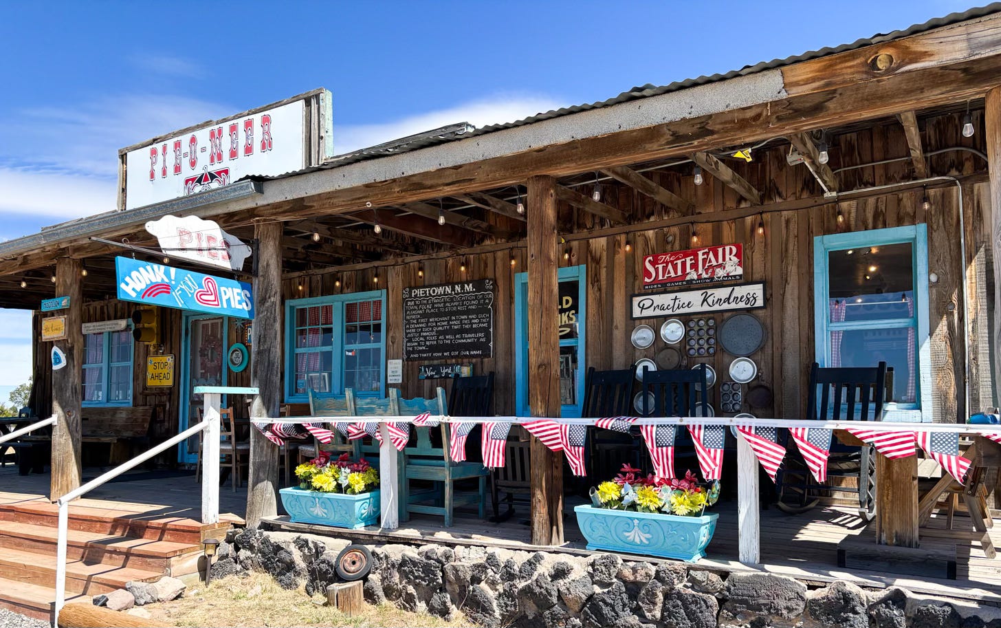 rustic log building decorated with flags, flowers and vintage signs