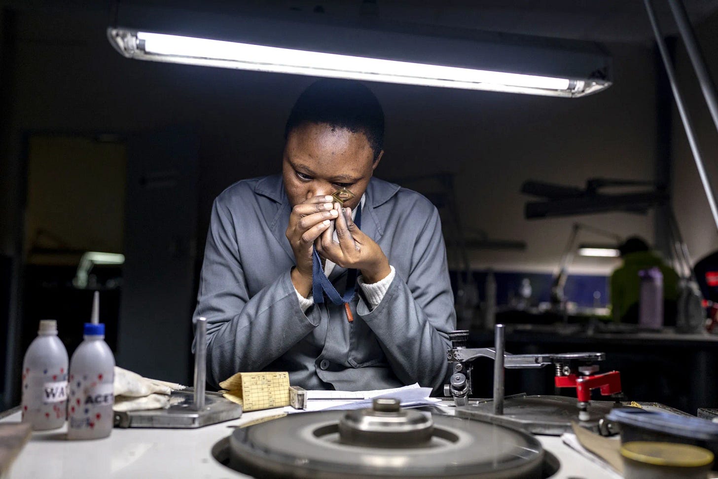 An female Aurostar technician closely examines a gemat the De Beers partner’s diamond processing plant in Gaborone, Botswana, in 2023.