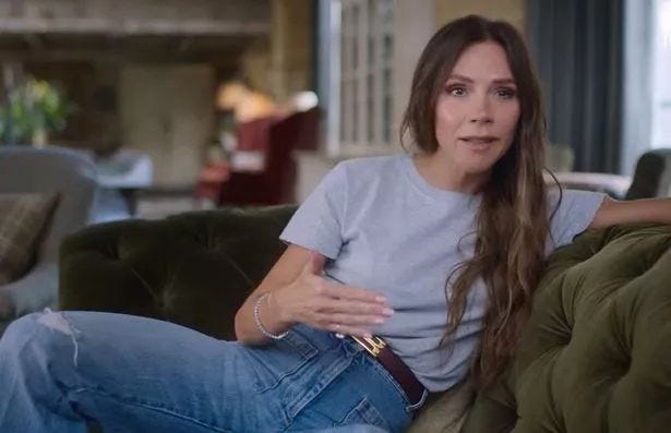 This may contain: a woman sitting on top of a green couch