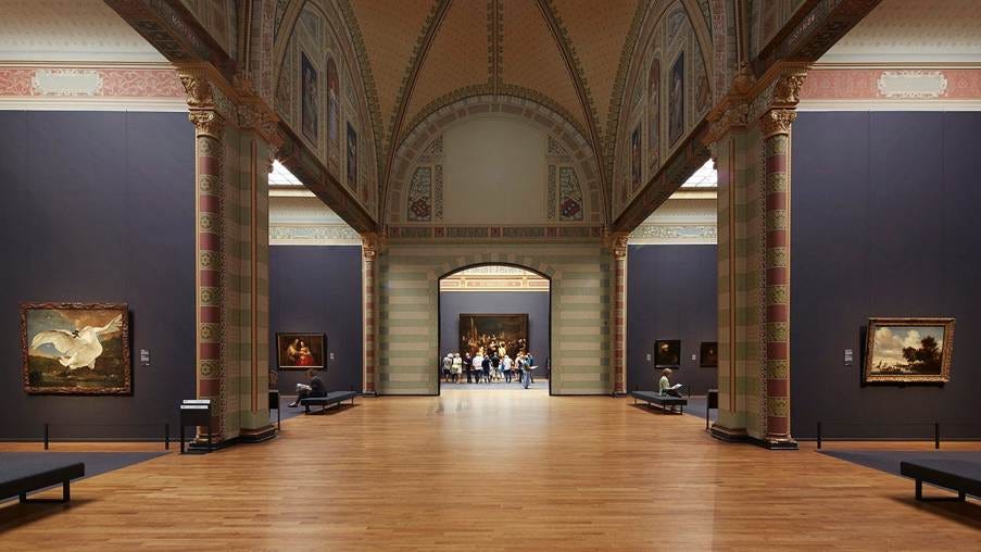 A large room with art and people in it

AI-generated content may be incorrect.