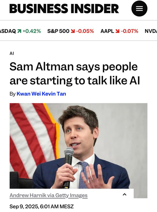 Sam Altman speaking at a podium with a microphone. He is wearing a suit and tie, gesturing with his hands. An American flag is visible in the background.