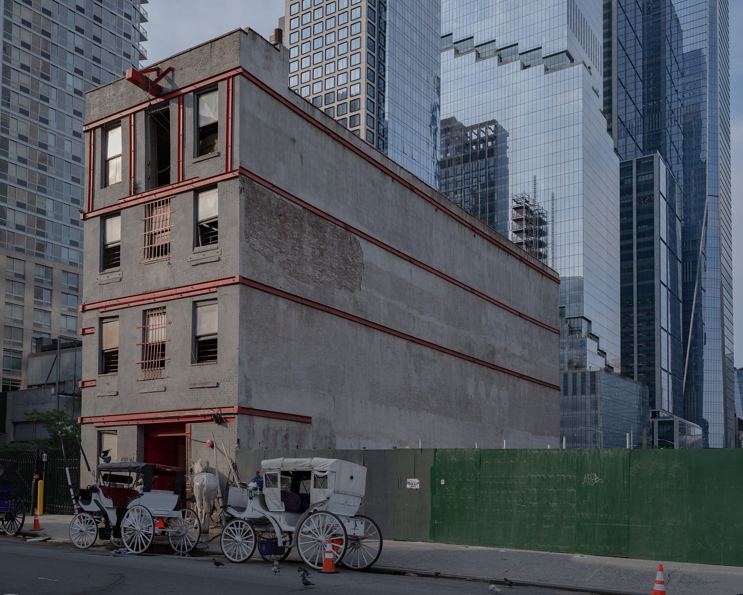 horse-getting-washed-in-front-of-stable-with-modern-buildings-in-background