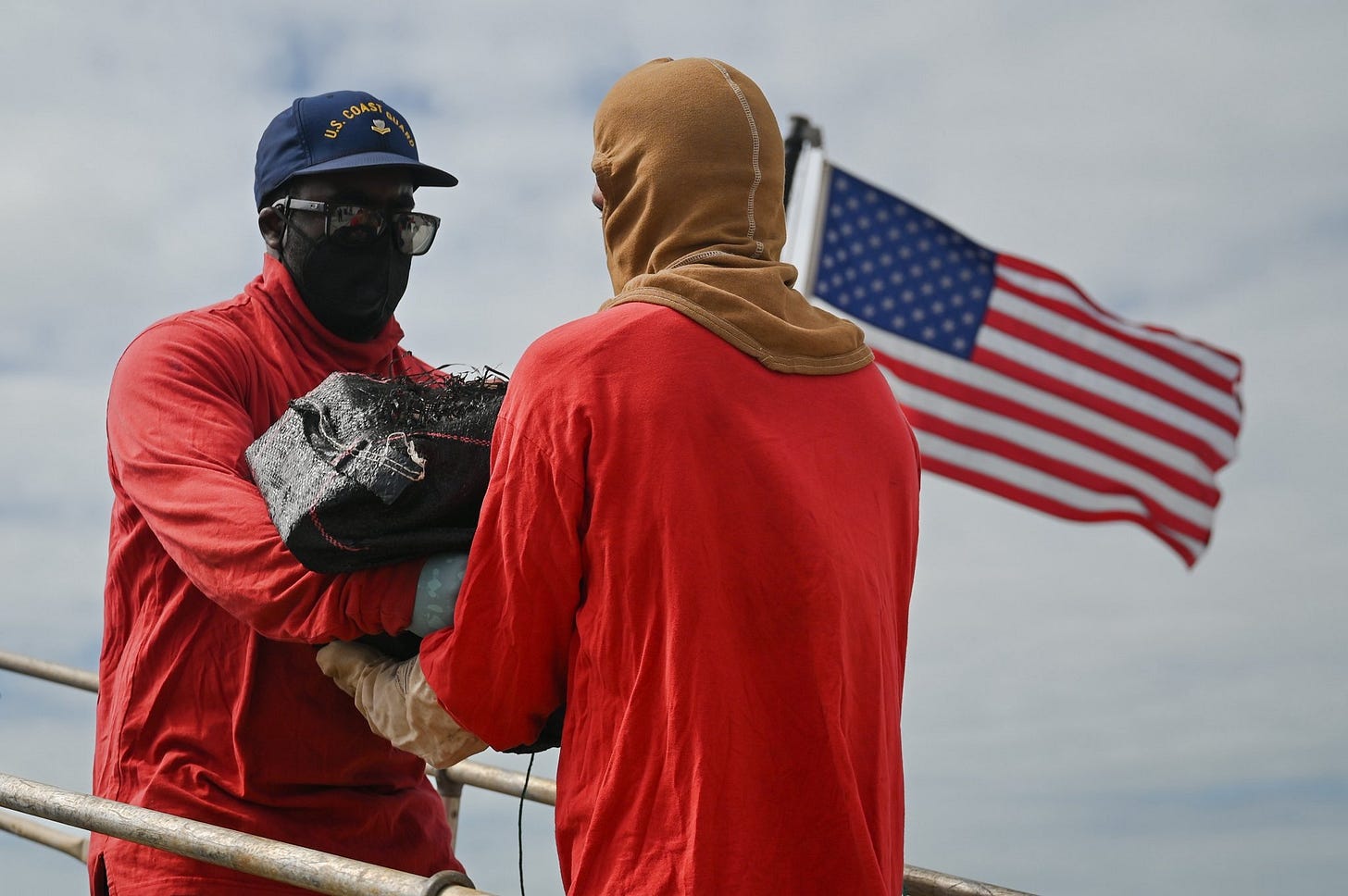 Crew members of the US Coast Guard Cutter “Tampa” offload a bale of cocaine seized from cartel drug smugglers during “Operation Pacific Viper” 