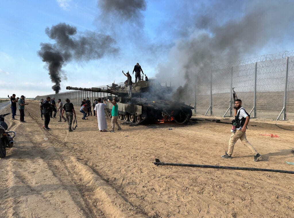 Members of the Izz ad-Din al-Qassam Brigades, the military wing of Hamas burn Israeli Armored Tank near Gaza on October 07, 2023. STR APA Images.  Mondoweiss Palestinian resistance in Gaza launches unprecedented surprise attack on Israel