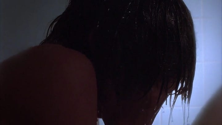 Two frame grabs from the shower scene showing Alex in profile with his hands to his face. In the second shot, a shift in lighting renders him in silhouette, amplifying the crow-like figure he's become.