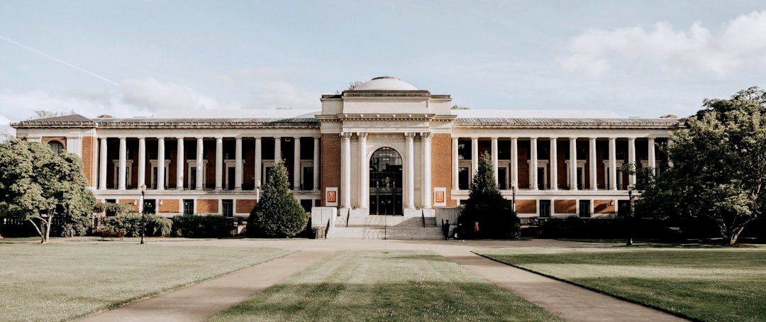 brown concrete building under white clouds during daytime