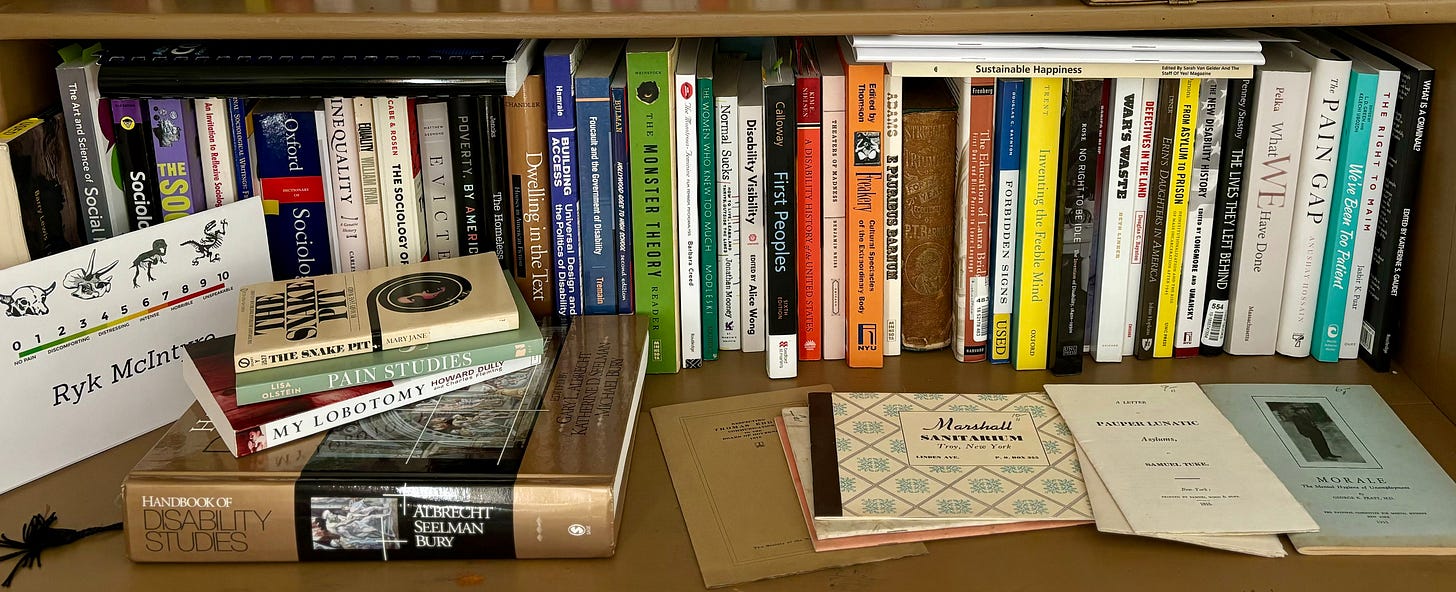 Panoramic color photograph of a single shelf in Rebecca's library with many books on the sociology of housing, poverty, inequality and more. Also included are many disability history and studies books, as well as encyclopedias, poetry, and memoirs.