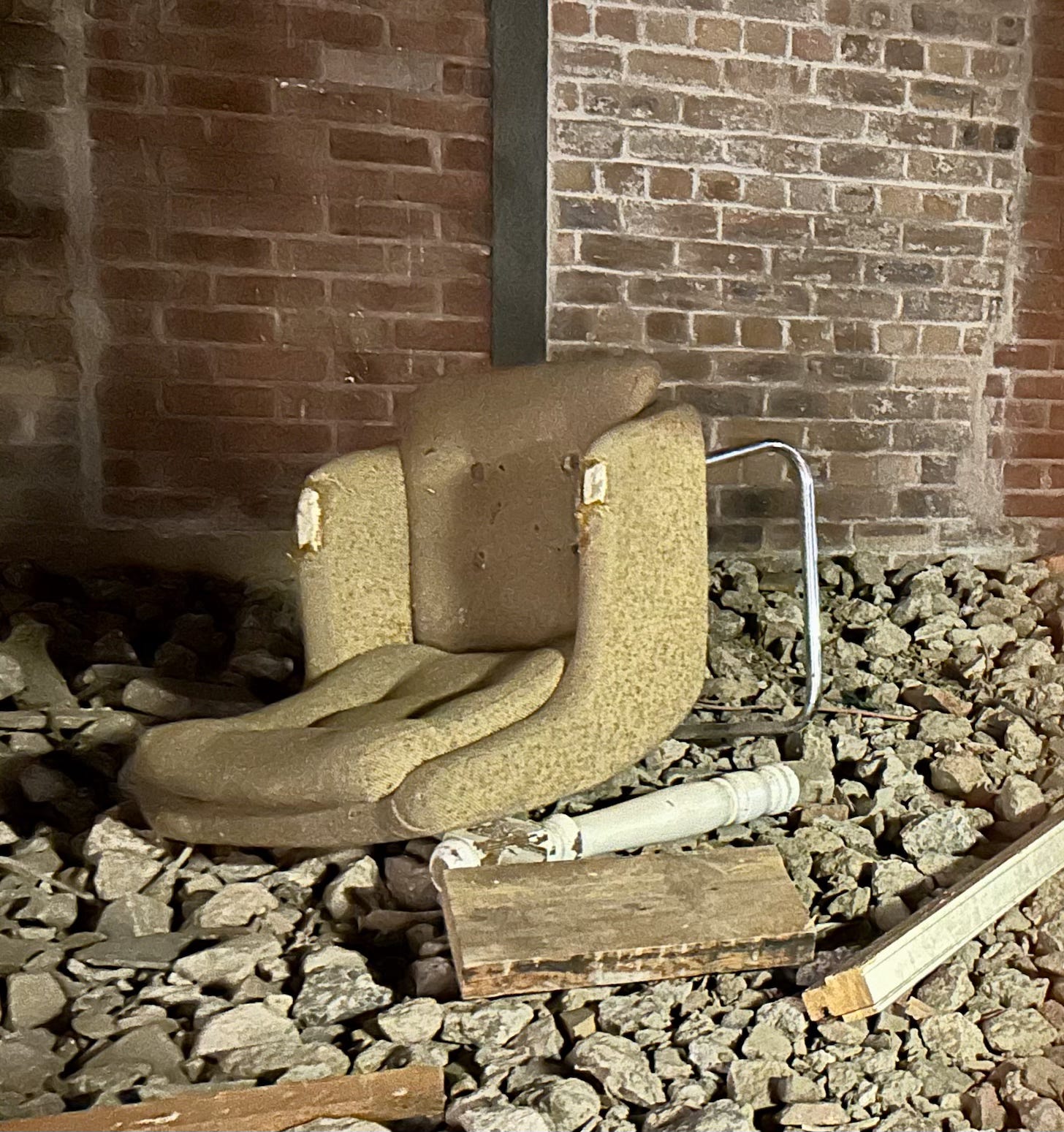 Mike Nelson art installation at Fruitmarket Edinburgh of an abandoned chair amongst building rubble.
