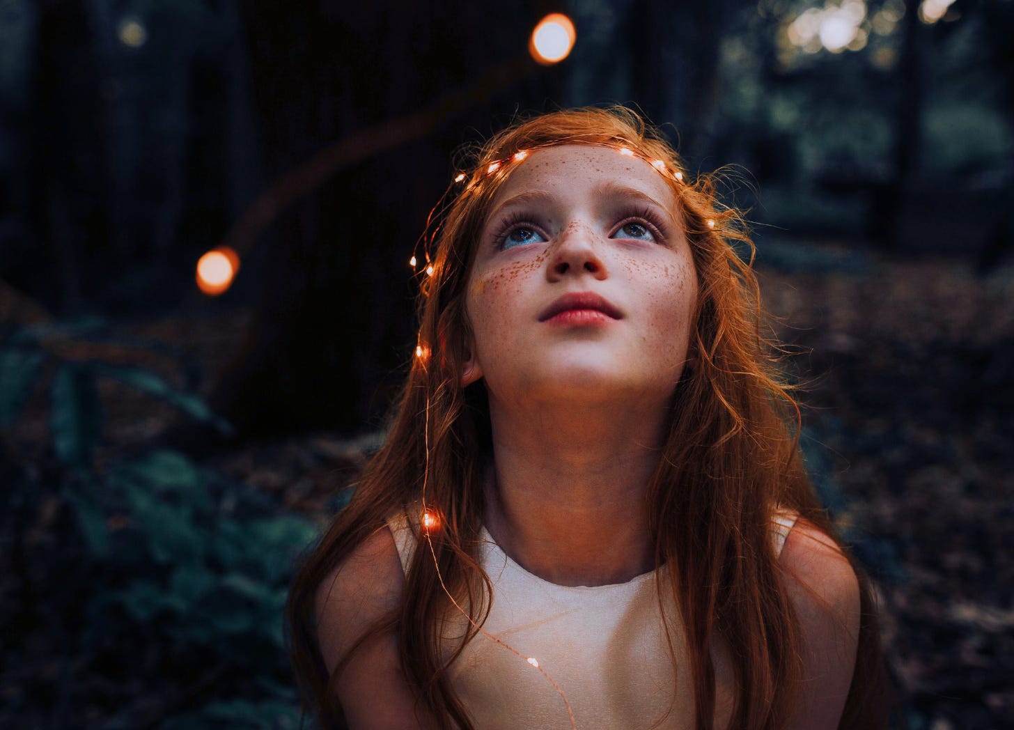 girl in woods looking up