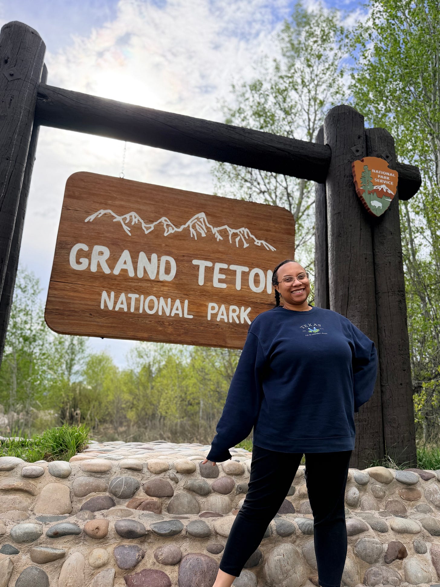 Ashley standing in front of Grand Teton National Park sign Ashley standing in front of Grand Teton National Park sign