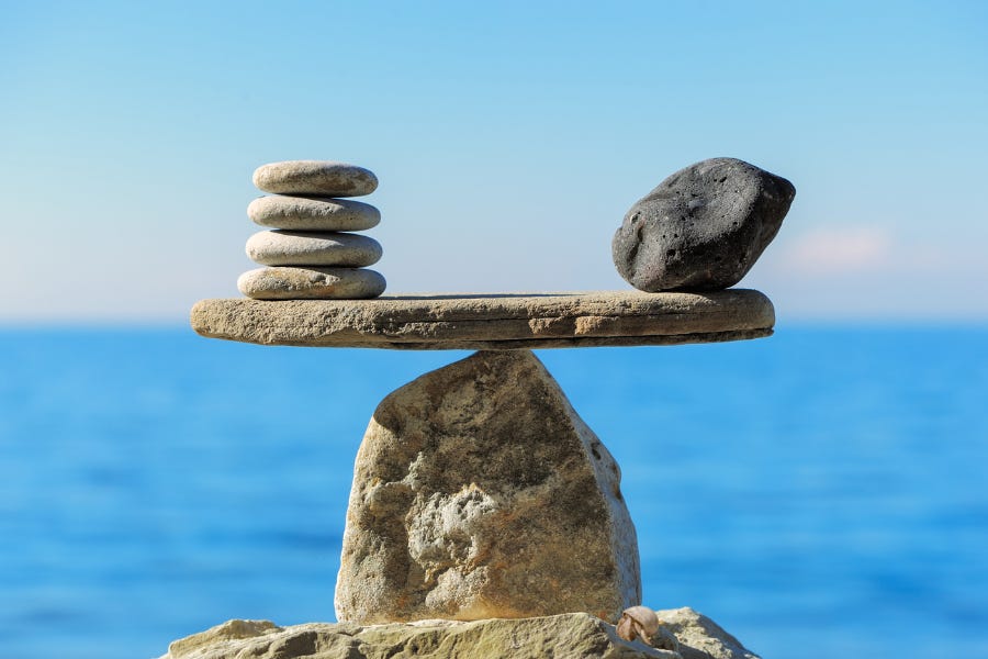 Stacked stones balanced on a rock by the sea, symbolizing harmony, balance, and inner stability. Stacked stones balanced on a rock by the sea, symbolizing harmony, balance, and inner stability.