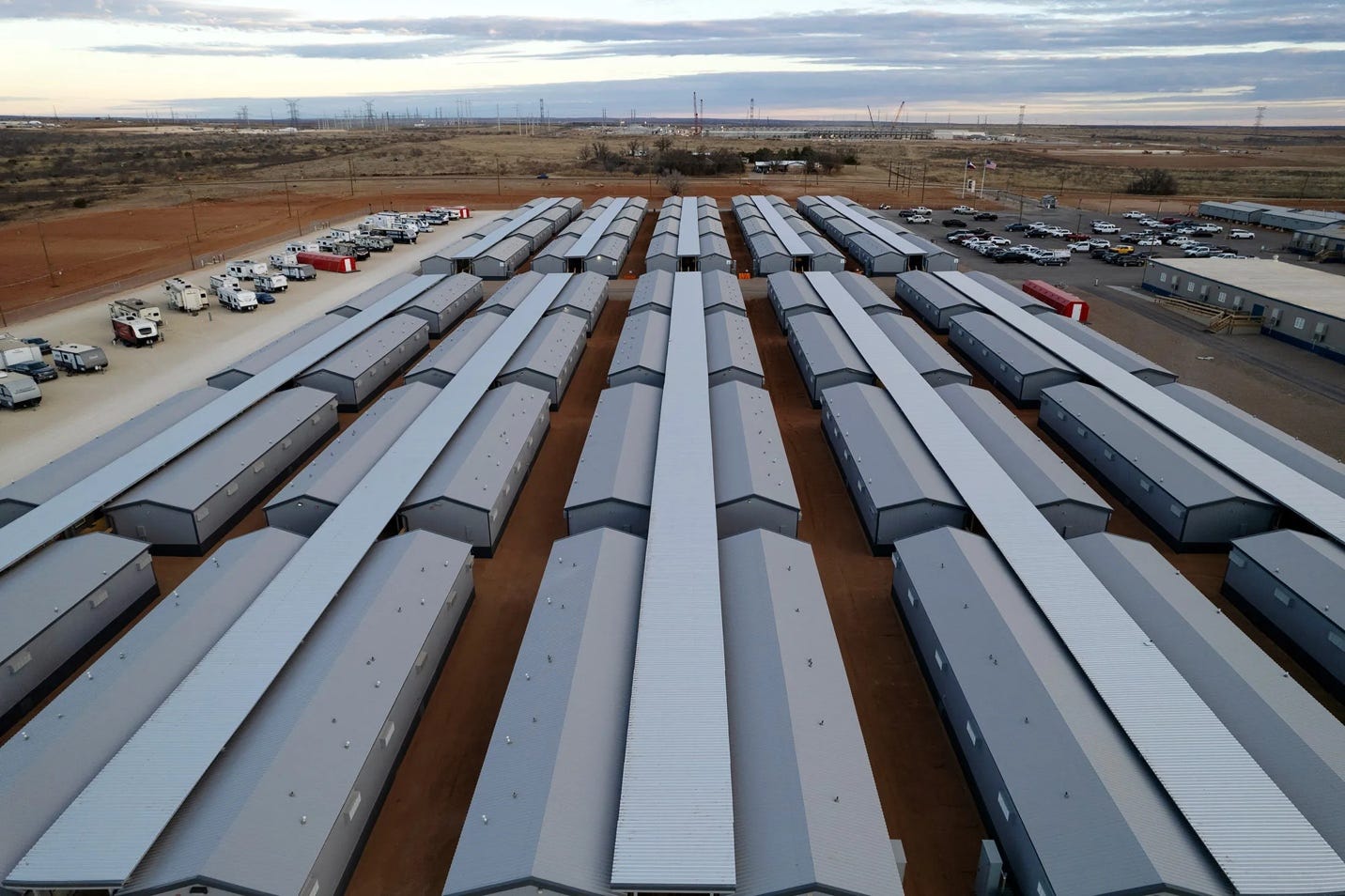 A large row of buildings as seen from above against the Texas sky, surrounded by RVs and cars.