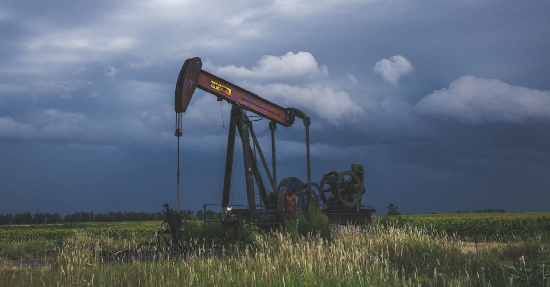 red and black heavy equipment on green grass field under white clouds during daytime