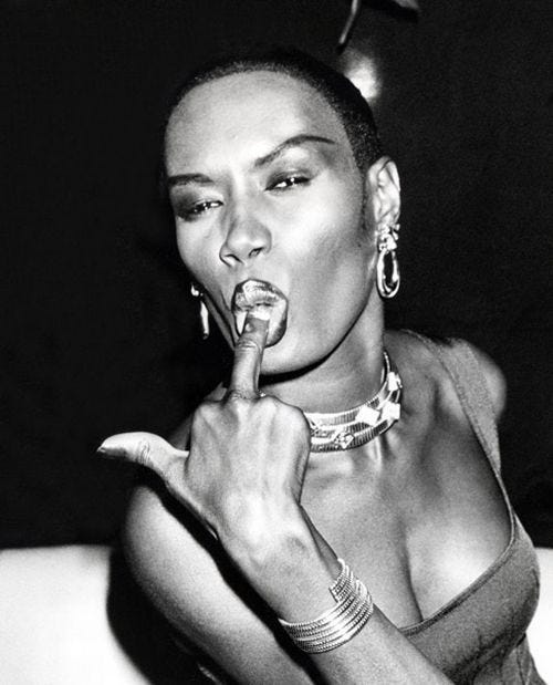 This may contain: a black and white photo of a woman with her finger in her mouth