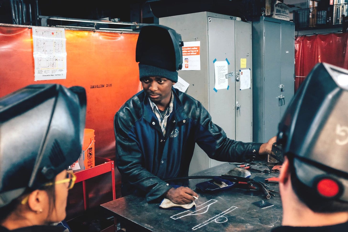 Welding instructor Robert Collins teaches students at The Crucible in Oakland, using chalk diagrams to explain MIG welding techniques.