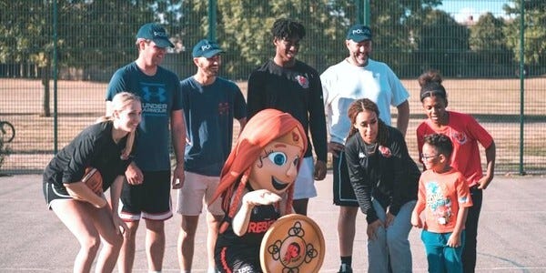 A group of adults and young people gather for a group photo