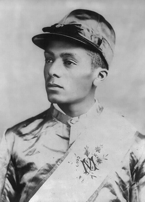 Black-and-white portrait of Isaac Burns Murphy, the famed nineteenth-century jockey, shown in racing silks and cap, looking off to the side with a composed expression.