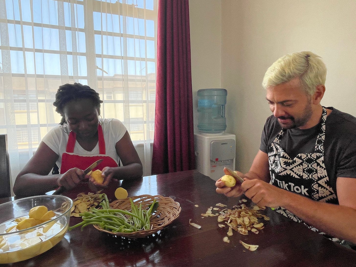 a woman and a man sitting at a table peeling potatoes