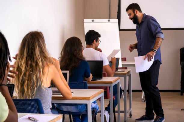 Group of students and a teacher in a classroom.