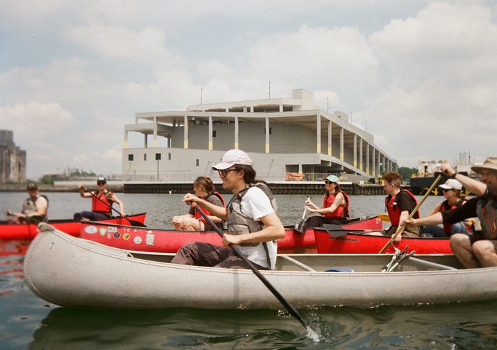 Photo 1: Canoers on the Gowanus Canal, Photo 2: Selfie of the author and friends at the farmer's market, Photo 3: Assortment of flowers on sale at the farmers market, Photo 4: New York skyline taken from a ferry taken in the day, slightly overexposed and hazy