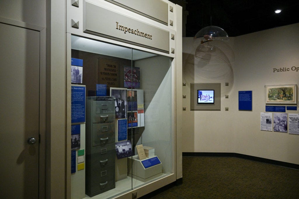 The impeachment exhibit and glass case, showing how small the placard actually is.