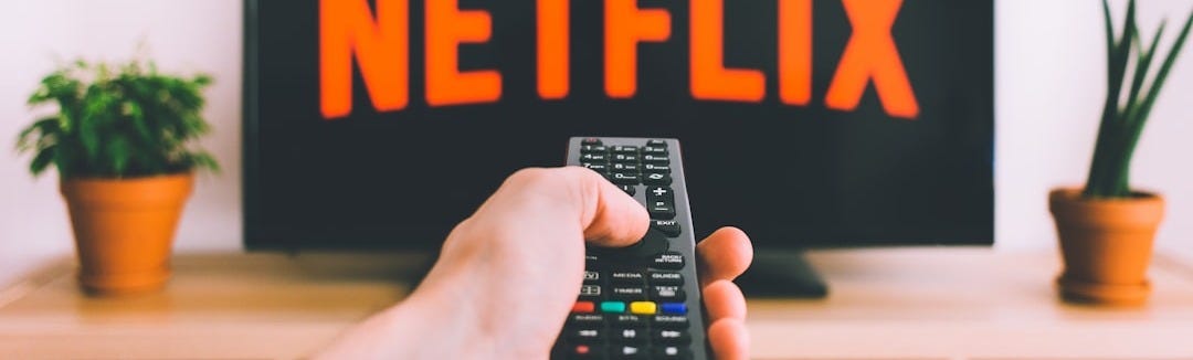 person holding remote pointing at TV